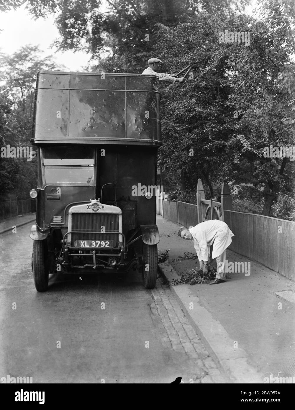 Wartungsmänner verwenden einen Doppeldeckerbus, um die überhängenden Äste oberhalb der Straße in Sidcup, Kent zu trimmen. 1937 Stockfoto