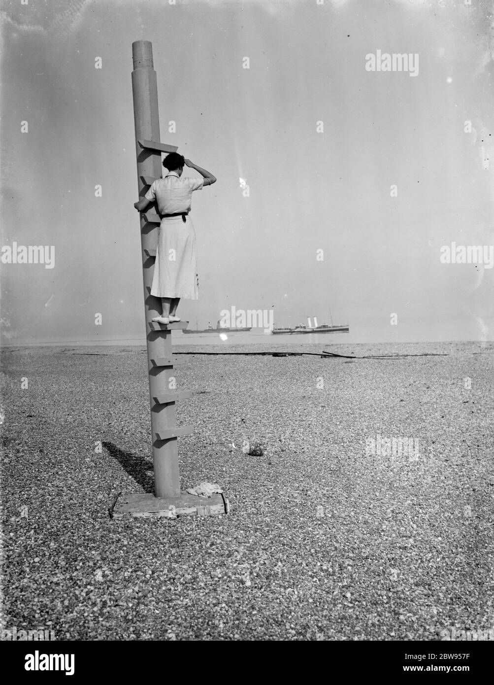 Eine Frau steht auf dem Aussichtsposten am Dungeness Beach in Kent. 1936 Stockfoto