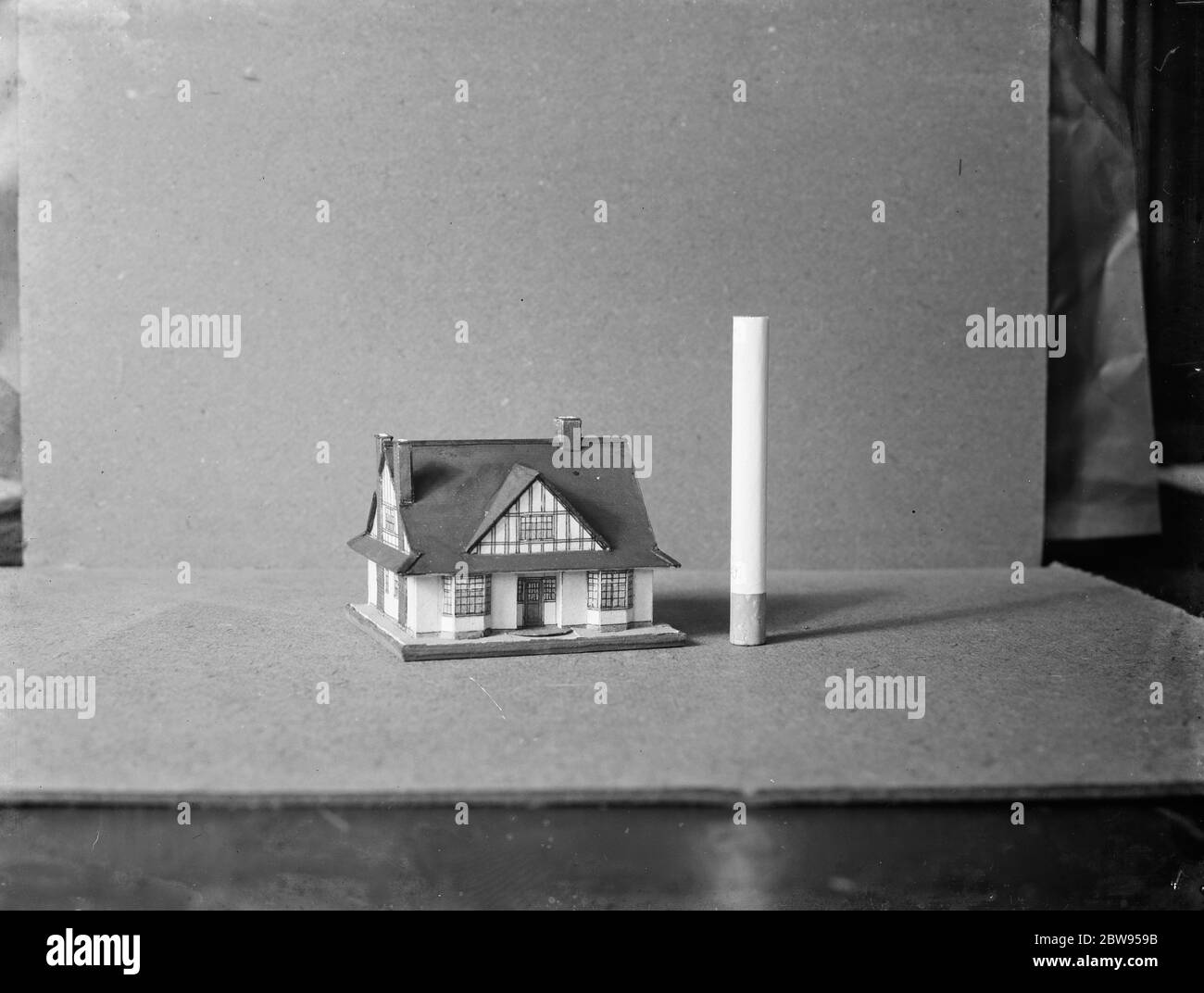 Ein Miniaturhaus neben einer Zigarette platziert, um eine Perspektive der Skala zu geben. 1936 Stockfoto