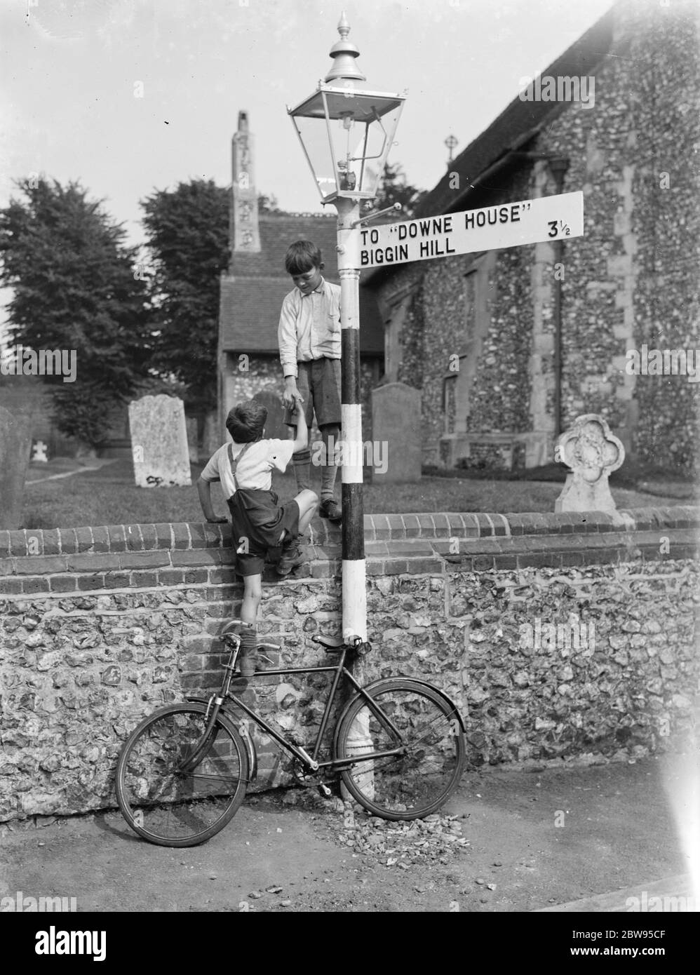Kinder spielen um eine Lampost neben der Kirche in Downe, London. 1936 Stockfoto