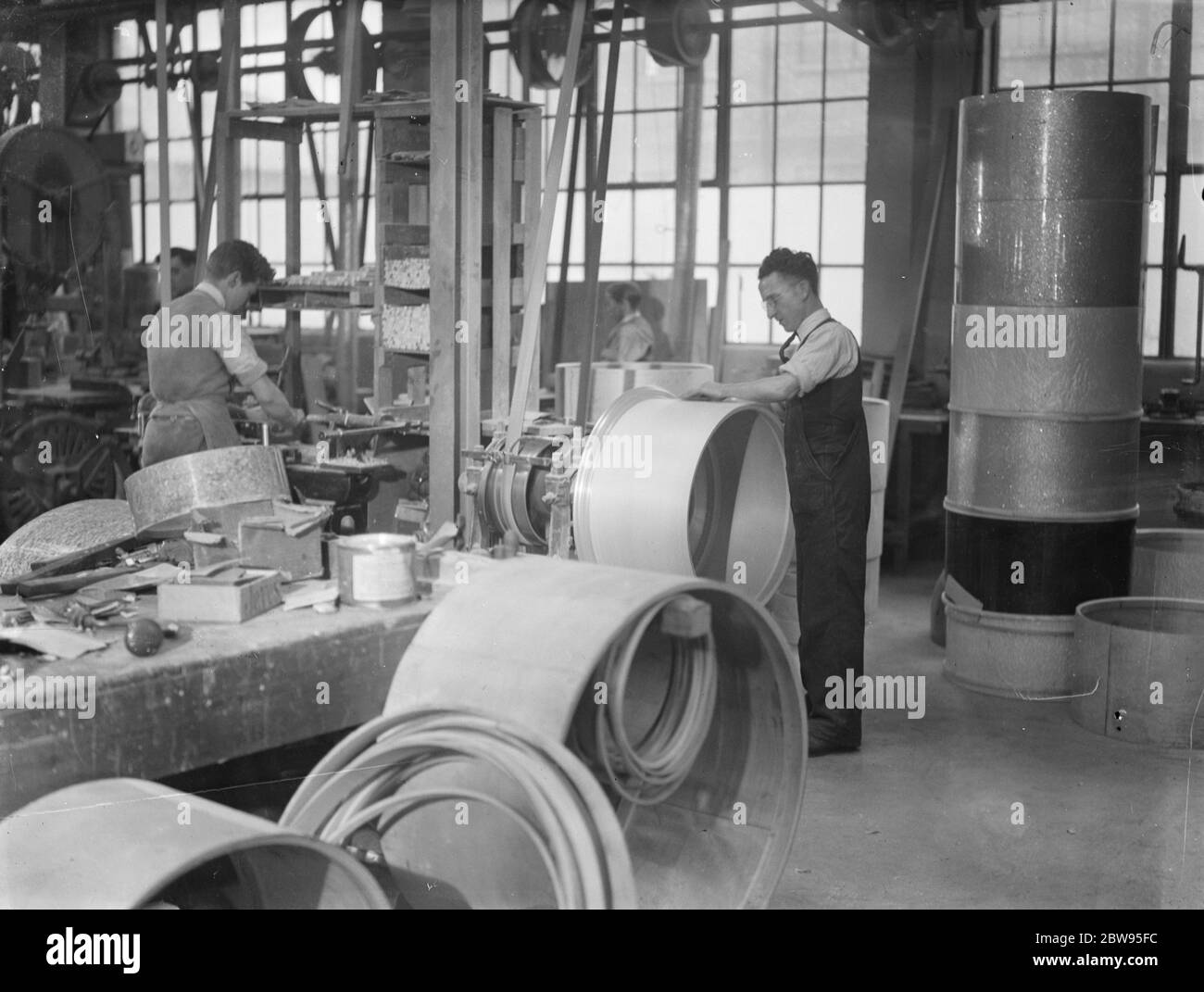 London 's großen Lärm, Drehen Schlagzeug durch die hundert. Trommeln , groß und klein , werden von den hundert in Acton , London , wo eine der größten Trommel Unternehmen Großbritanniens hat seine Fabrik . Qualifizierte Mitarbeiter kämpfen, um Sperrholz und Ferkel in die drms, die ihren Weg in Symphonieorchester und Jazz-Bands finden verwandeln. Die geringste Variation in der Kurve des Körpers oder die Spannung des Schweinshautes führt zu einem veränderten Ton und spezielle Zinnräume wurden gebaut, wo Anpassungen vorgenommen werden können, ohne den Rest des Personals übermäßig zu stören. Das Schweinsleder über den Plywoo legen Stockfoto