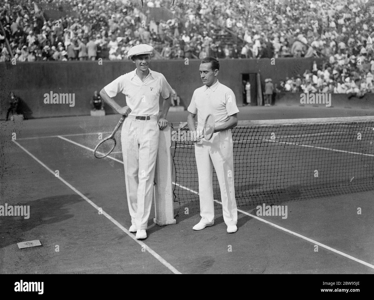 Borotra schlägt Reben in Singles des Davis Cup zwischen Amerika und Frankreich in Paris. J Borothra aus Frankreich schlug Ellsworth Vines of America , den Gewinner der Wimbledon Championships 6-4 , 6-2 , 3-6 , 6-4 , in den Singles der Davis Cup Challenge Runde zwischen Frankreich und Amerika im Stade Roland Garros in Paris . Reben und Cochet am Netz . 29 Juli 1932 Stockfoto