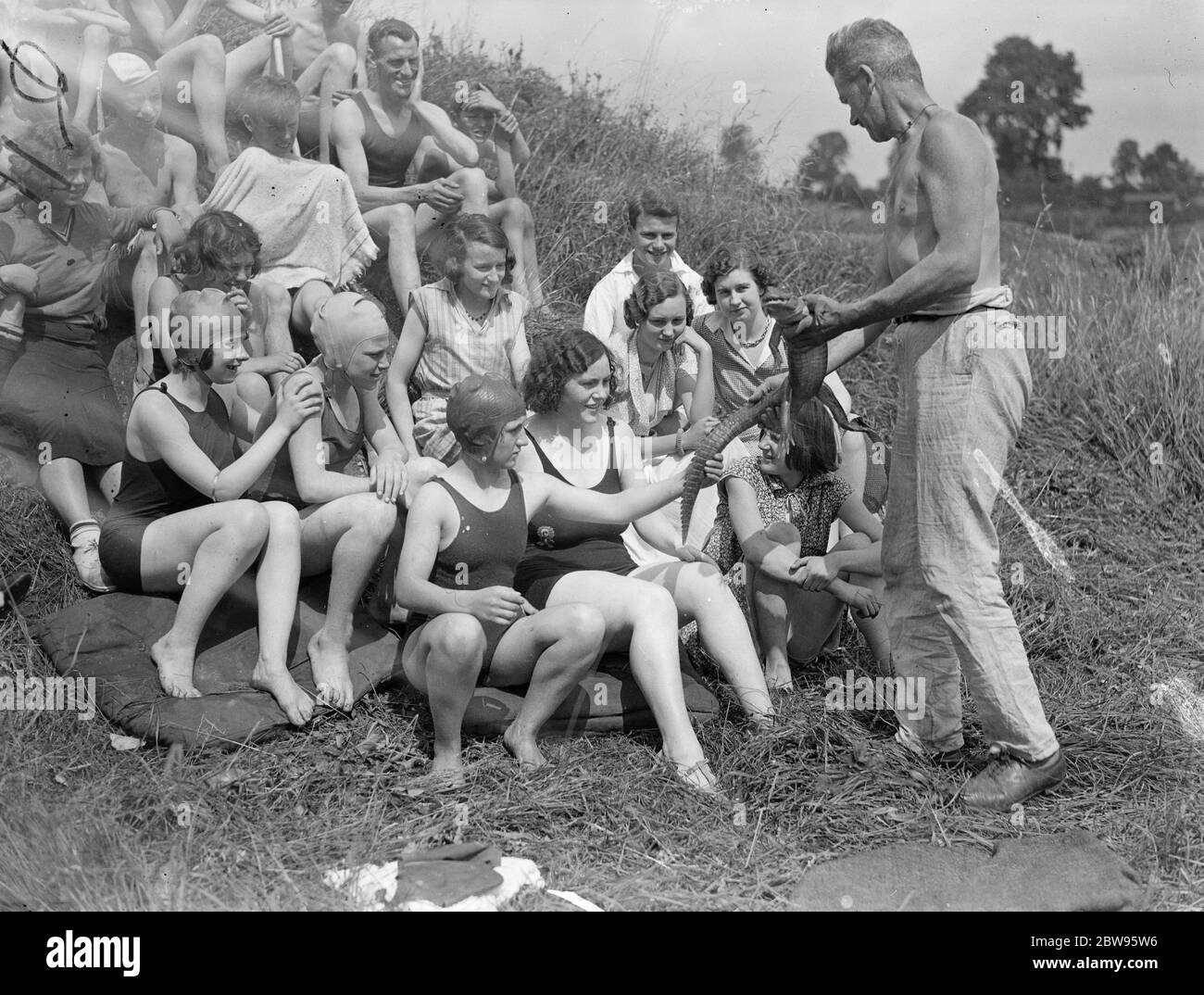 Wildjäger und Entdecker im Camp an der Themse. Captain Sarll, der große Wildjäger und Entdecker zeigt eine Party von Feriencamper in Shepperton, ein 10 Jahre alter Alligator, die er nach England von einer Wildjagd im Ausland gebracht. August 1932 Stockfoto