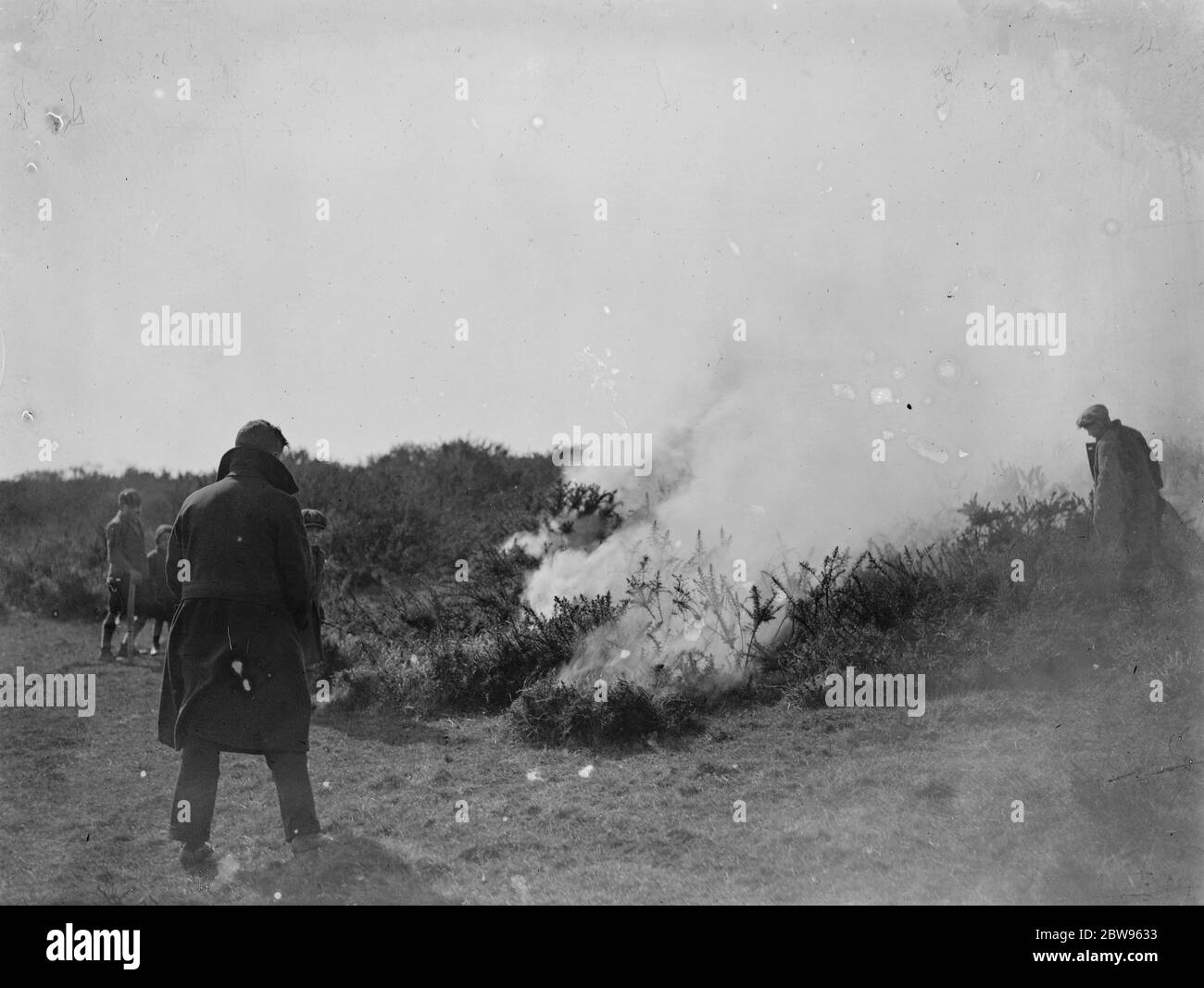 Große gemeinsame Feuer in der Nähe von Eastbourne . Ein großes gemeinsames Feuer lag Abfälle Hektar Heide in der Nähe von Birling Gap , die berühmte Sussex Schönheit Ort in der Nähe von Eastbourne . Kinder beobachten die brennende gemeinsame während des Feuers . 26 März 1932 Stockfoto