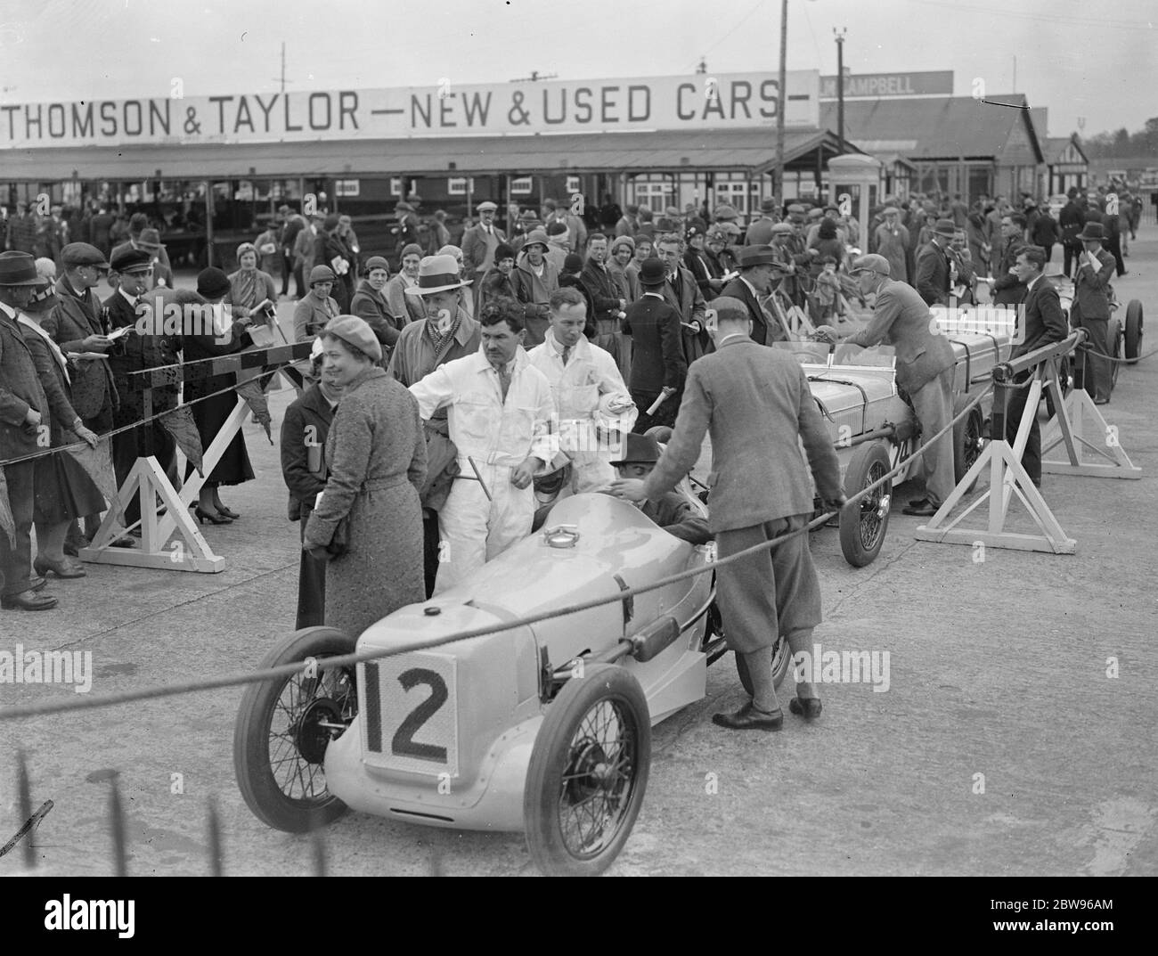 Rennen um British Empire Trophäe in Brooklands . Viele berühmte britische Rennfahrer Reihen sich am Start des British Racing Drivers Club , Empire Trophy Race , auf dem Brooklands Track , Weybridge , Surrey . Die Szene im Fahrerlager als die Autos zur Startlinie gingen. 30. April 1932 Stockfoto