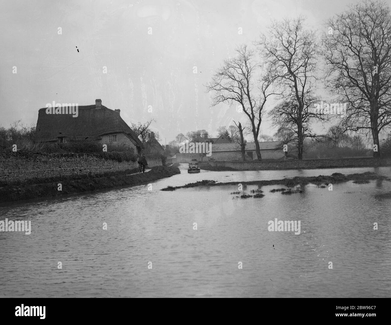 Fluss vollständig untergetauchts Oxfordshire Straße. Der River Ray brach seine Ufer bei Islip und vollständig untergetaucht die Oxford - Wheatley Straße für mehrere hundert Meter. Die Straße neu liegt unter zwei Füßen Wasser. Die untergetauchte Straße bei Islip. Mai 1932 Stockfoto