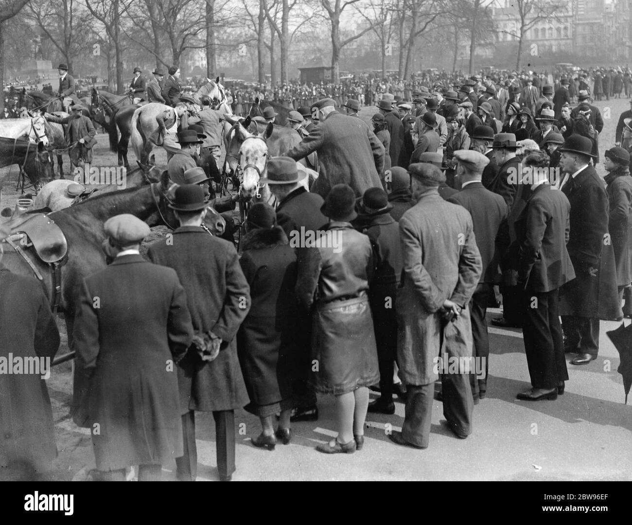 Große Menschenmengen genießen Frühlingssonne im Park. Eine ungewöhnlich große Menge war im Hyde Park London, um den Sonnenschein des ersten Frühlings Sonntag des Jahres zu genießen. Beobachten Reiter ihre Pferde nach dem Reiten in der Reihe absatteln. 20 März 1932 . Stockfoto