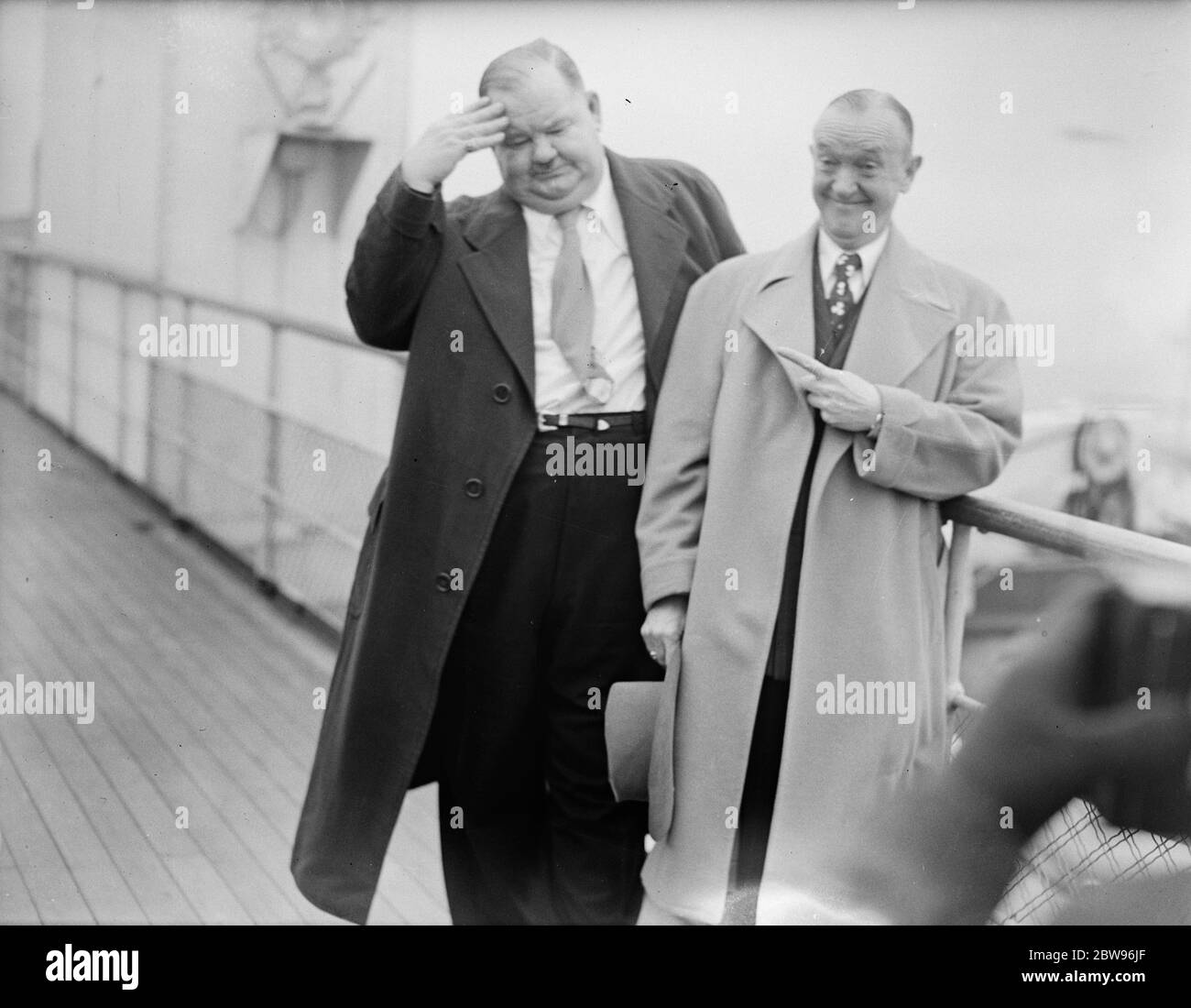 Laurel und Hardy kommen in Großbritannien auf der Queen Elizabeth. Oliver Hardy, der sperrige Hollywood-Filmkomödiant, und sein glum aussehender Partner Stan Laurel, kamen an Bord des Liners Queen Elizabeth in Southampton an. Dies ist ihr erster Besuch in Großbritannien seit 1932. Während ihres Besuchs werden sie auf Tour mit einem Skit namens Getting a Driving License gehen. Sie öffnen in Newcastle, gehen Sie weiter nach Birmingham, und dann zum Palladium in London. Es ist zwei Jahre her, dass Laurel und Hardy einen Film gedreht haben, sie sind in Vaudeville auf Tour und spielen Truppen. Stan Laurel (links) und Oliver Hardy (rechts Stockfoto