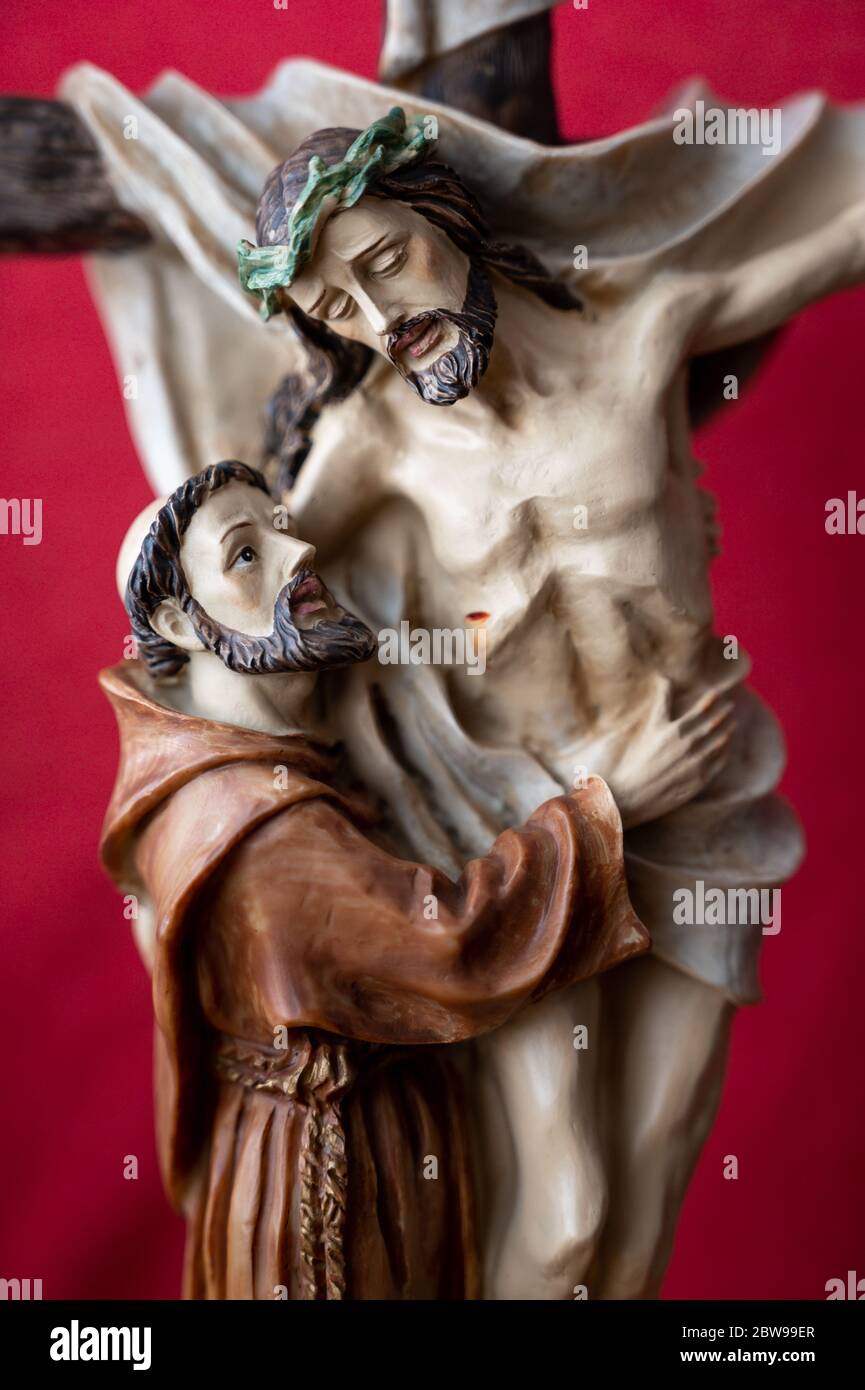 Statue des heiligen Franziskus von Assisi umarmt gekreuzigten Jesus. Eine private Kapelle. Slowakei, 2020/5/15. Stockfoto