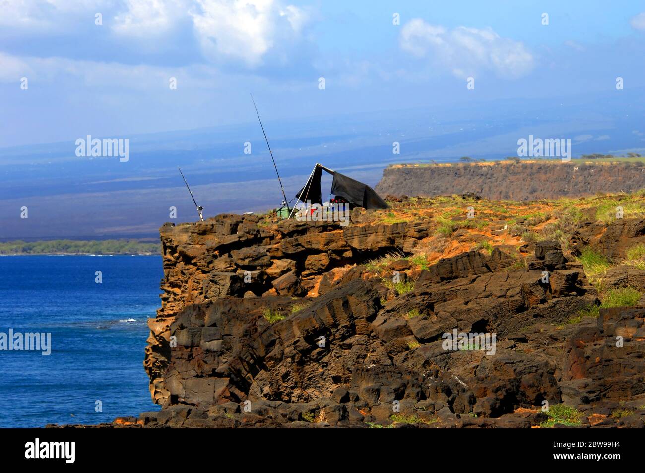 Steile, felsige Klippe dient als Camping für eineinstrigen Fischer in South Point, Big Island, Hawaii. Stockfoto