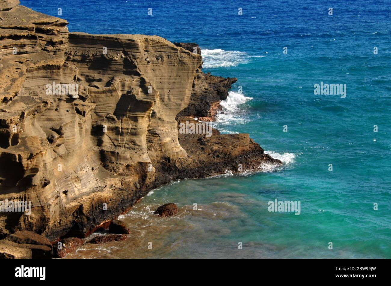 Klippe Seite des Green Sand Beach, Big Island von Hawaii, Wind und Wellen Erosion ist in der Sandstein Felswand zu sehen. Aqua blaues Wasser und Wellen surro Stockfoto