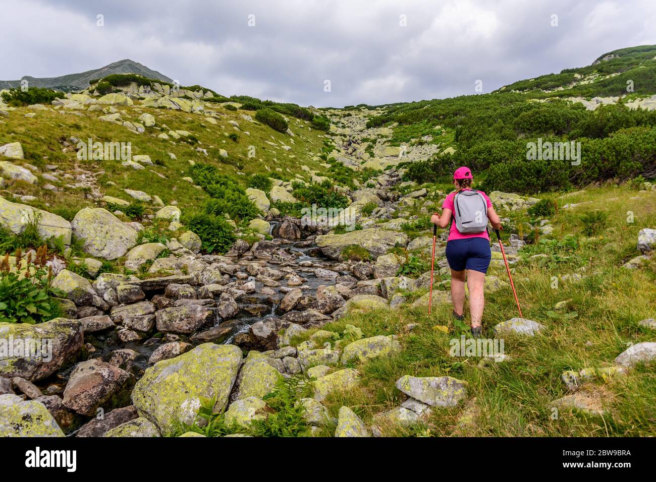 Mädchen mit farbigen Hemd und Hut zu Fuß auf hohen Berg grünen Wanderwegen in den Karpaten Stockfoto