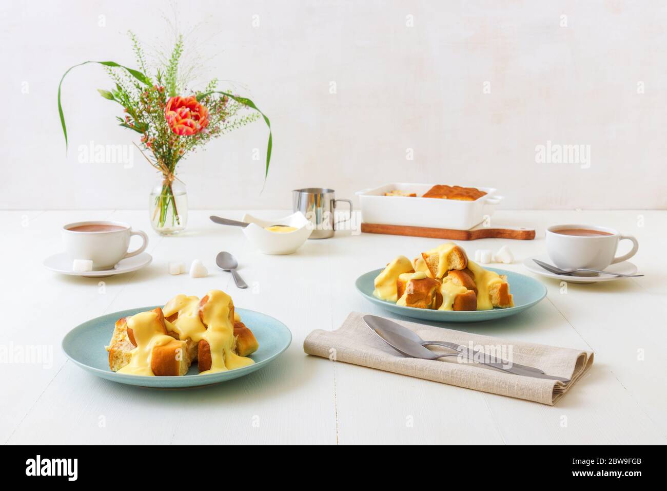 Hefepastete Brötchen mit Zabaglione oder Vanillecreme, oder Eierlikör, süßes Dessert oder Hauptgericht. Weißer Holztisch Hintergrund. Stockfoto