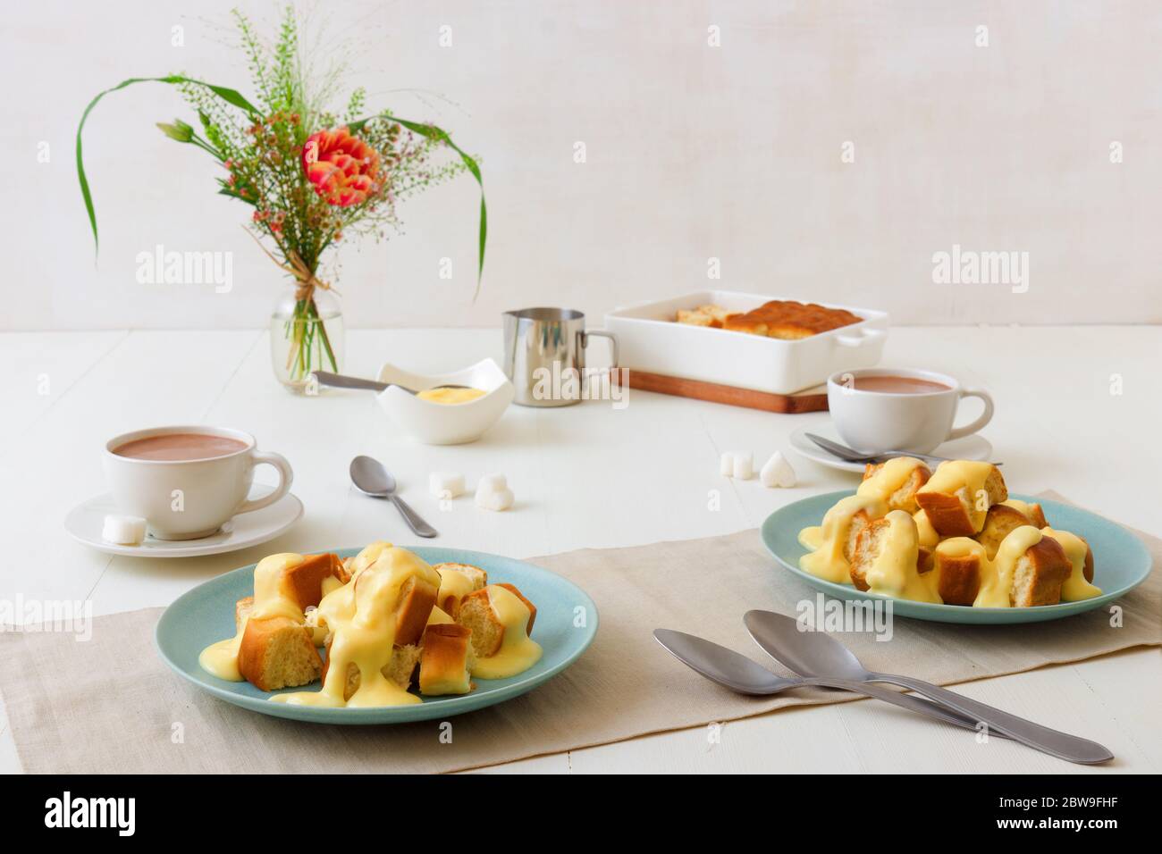 Hefegebäck mit Zabaglione oder Vanillecreme oder Eierkuchen, süßem Dessert oder Hauptgericht. Weißer Holztisch Hintergrund. Stockfoto