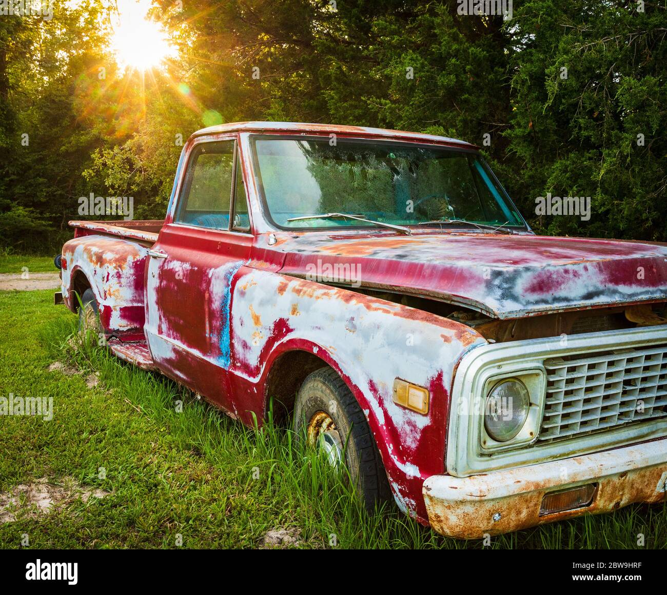 Antike rote LKW in einem Feld auf einem Bauernhof geparkt Stockfoto