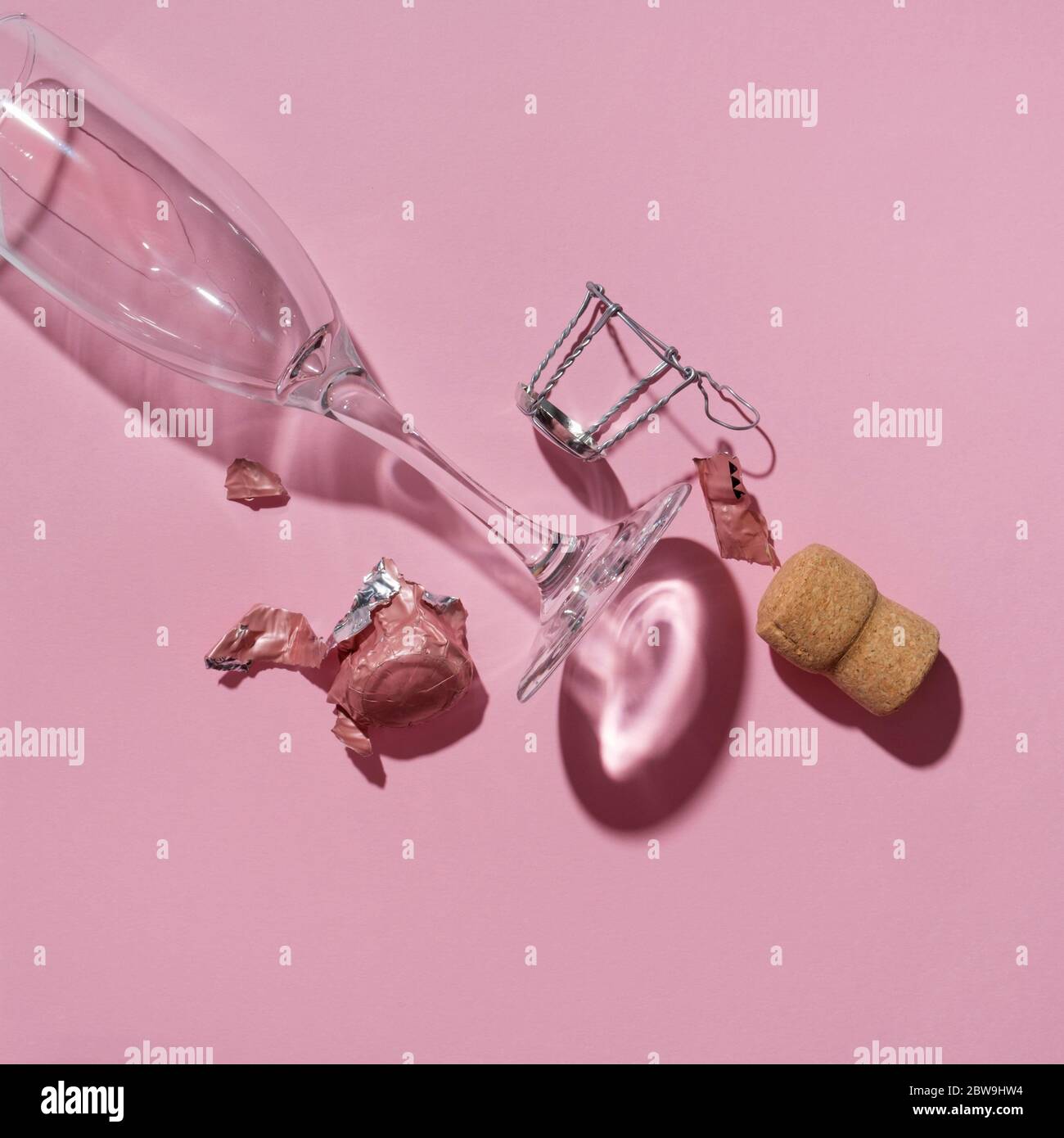 Studioaufnahme von Champagner Kork und leerem Weinglas auf rosa Hintergrund Stockfoto