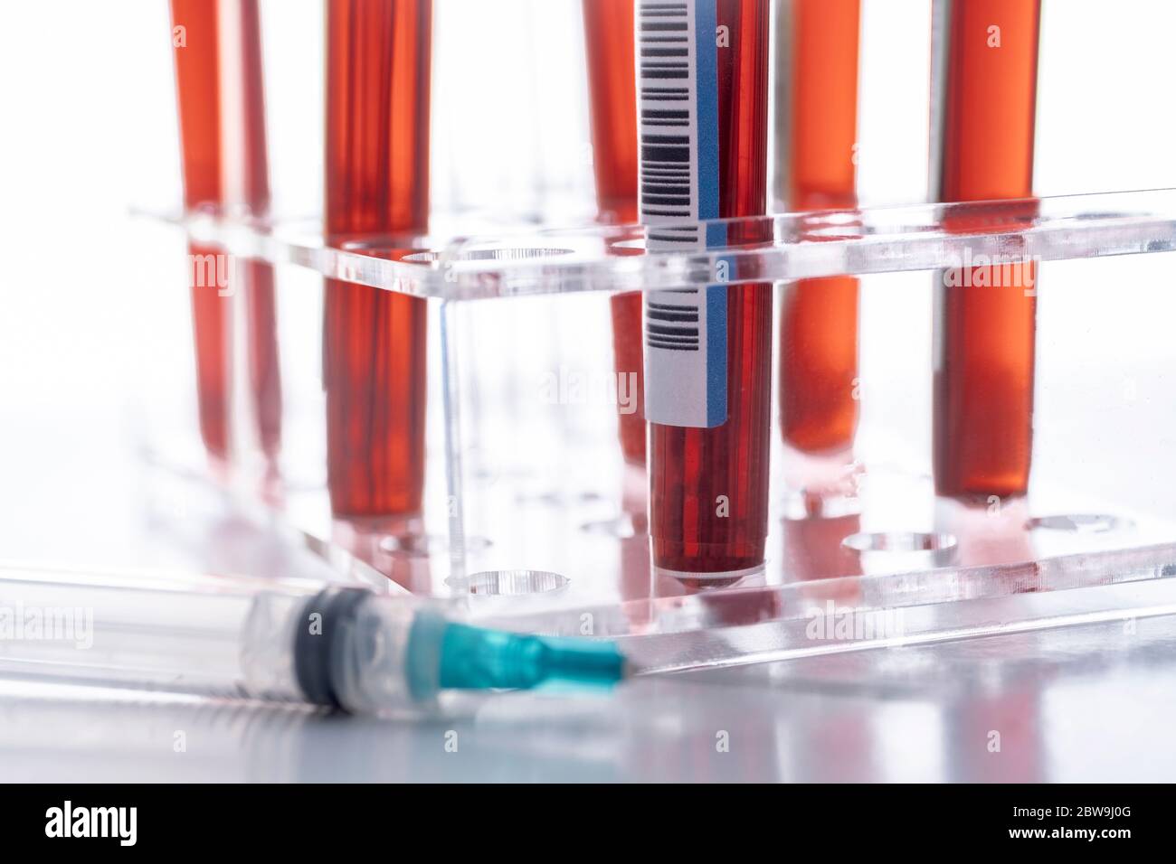 Studioaufnahme von Covid-19 Blutproben im Reagenzglasgestell Und Spritze Stockfoto