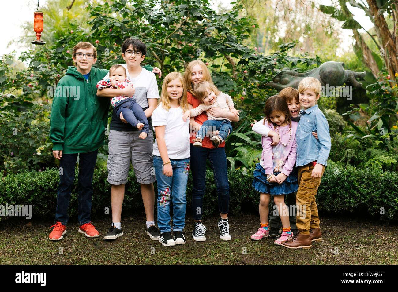 USA, California, Orange County, Gruppe von Kindern (12-17 Monate, 2-3, 6-7, 10-11, 12-13, 14-15) posiert im Garten Stockfoto