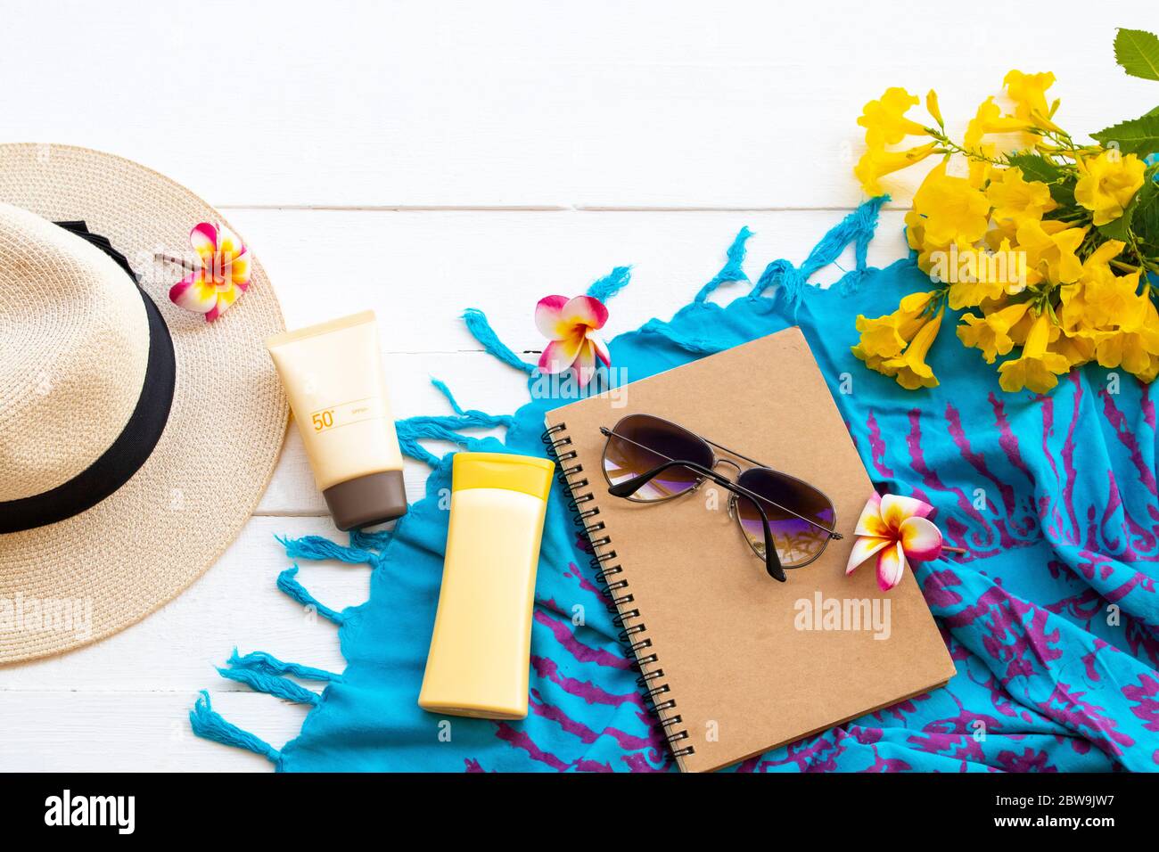 Sonnencreme spf50, Körperlotion Gesundheitspflege für die Haut mit Sonnenbrille, Hut, Notizbuch Planer, Schal und Blumen des Lebensstils Frau entspannen Sommer auf weiß Stockfoto