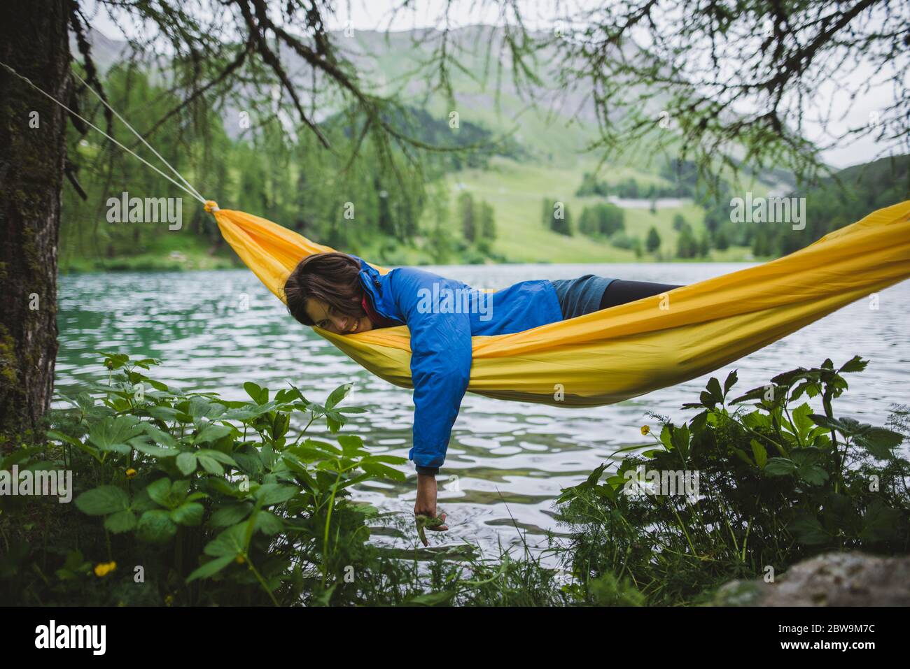 Schweiz, Bravuogn, Palpuognasee, Junge Frau in Hängematte am Palpuognasee in den Schweizer Alpen Stockfoto