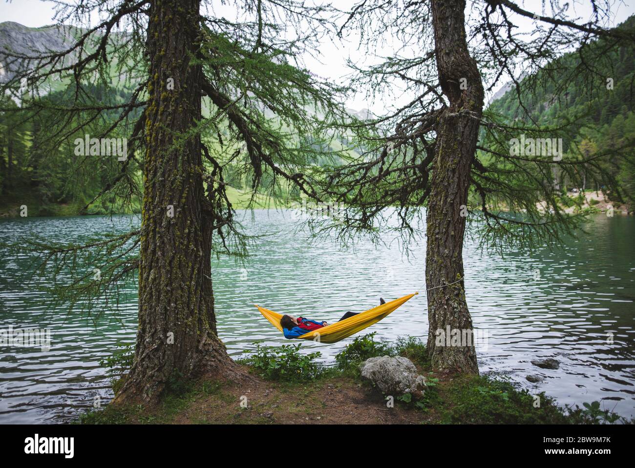 Schweiz, Bravuogn, Palpuognasee, Junge Frau in Hängematte am Palpuognasee in den Schweizer Alpen Stockfoto