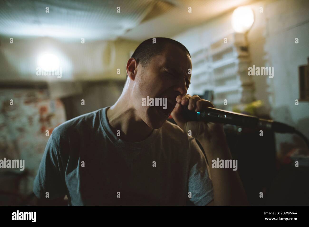 Junger Mann singt während der Probe in der Garage Stockfoto