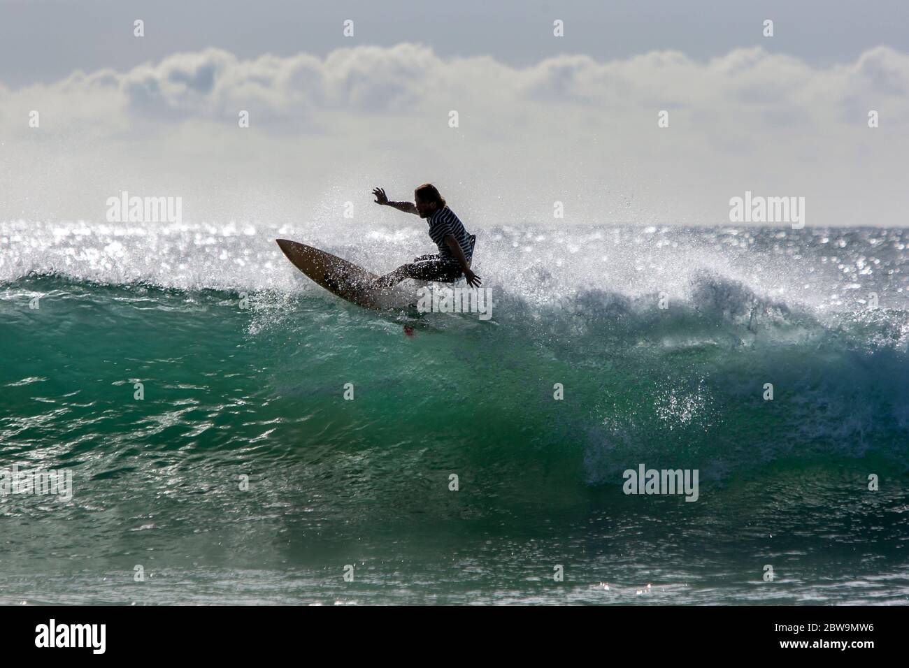 Ein Surfer reitet am frühen Morgen eine Point Break Wave in Arugam Bay in Sri Lanka. Stockfoto