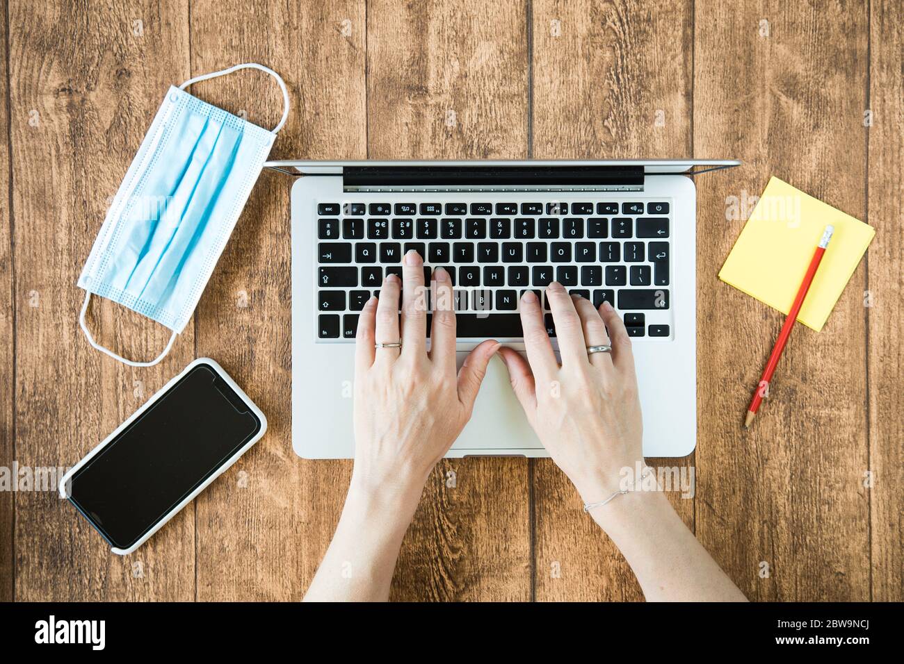 Arbeiten von zu Hause aus auf einem Computer während der COVID-Pandemie. Weibliche Person, die im Home Office einen Laptop verwendet. Stockfoto