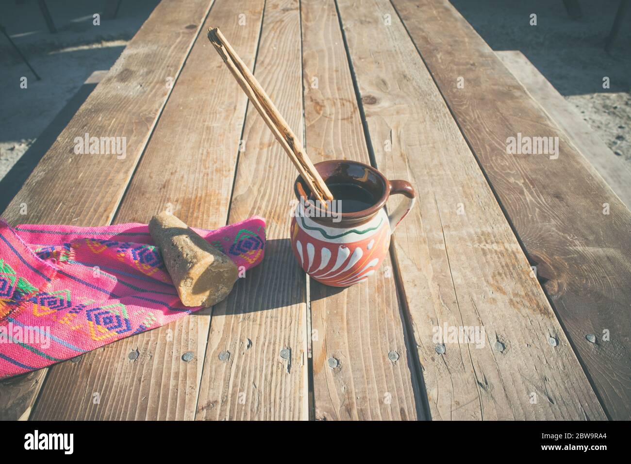 Mexikanischer Kaffee (Café de la olla) mit Zimt und braunem Zucker auf mexikanischem Serape Stockfoto