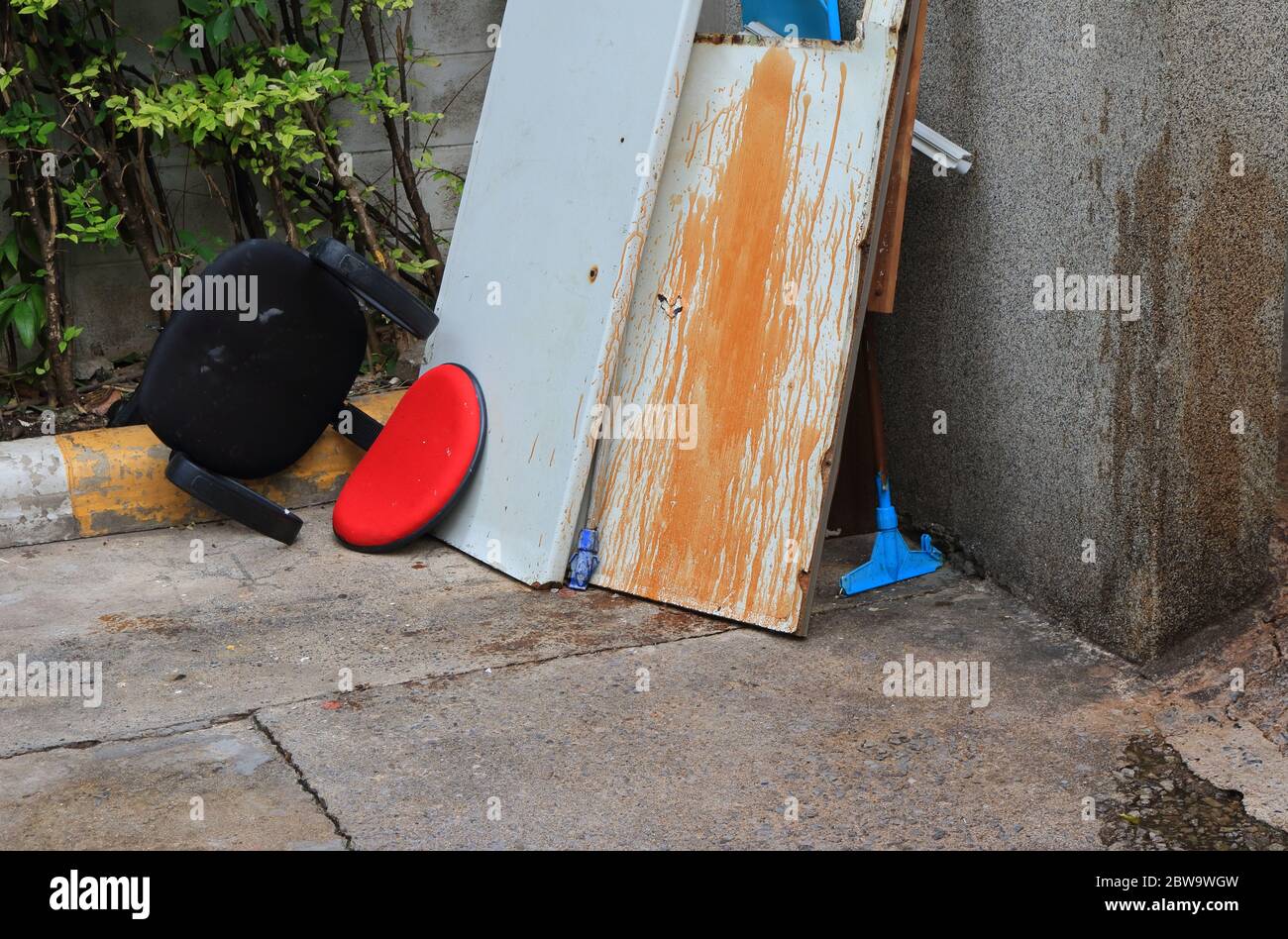 Closeup rote Rückenlehne aus verlassenen Kunstleder Stuhl umgedreht, weggeworfen am Straßenrand in der Nähe Müllplatz warten auf Recycling-Prozess Stockfoto