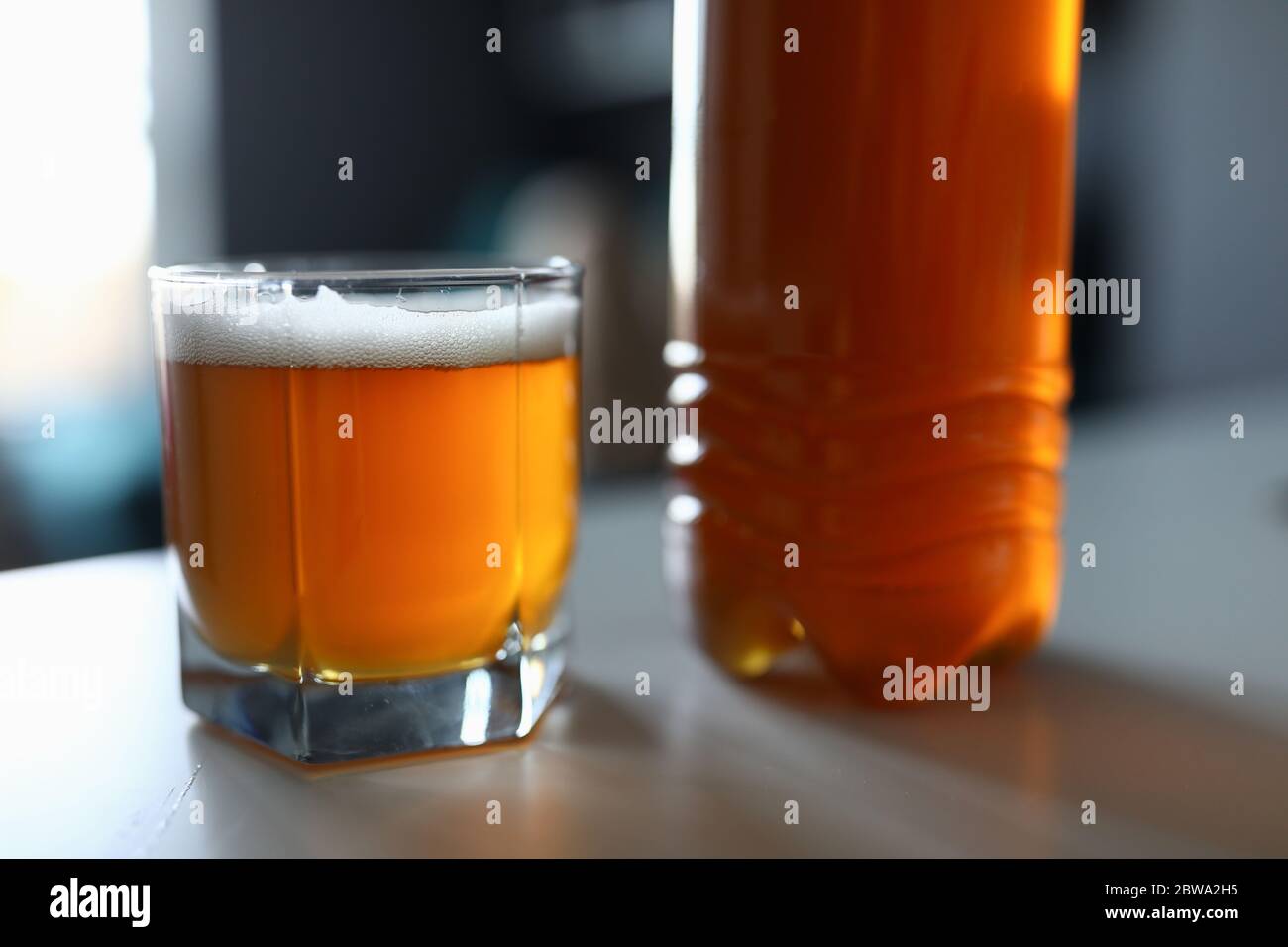 Auf dem Tisch ist eine volle Flasche und ein Glas frisches Bier Stockfoto