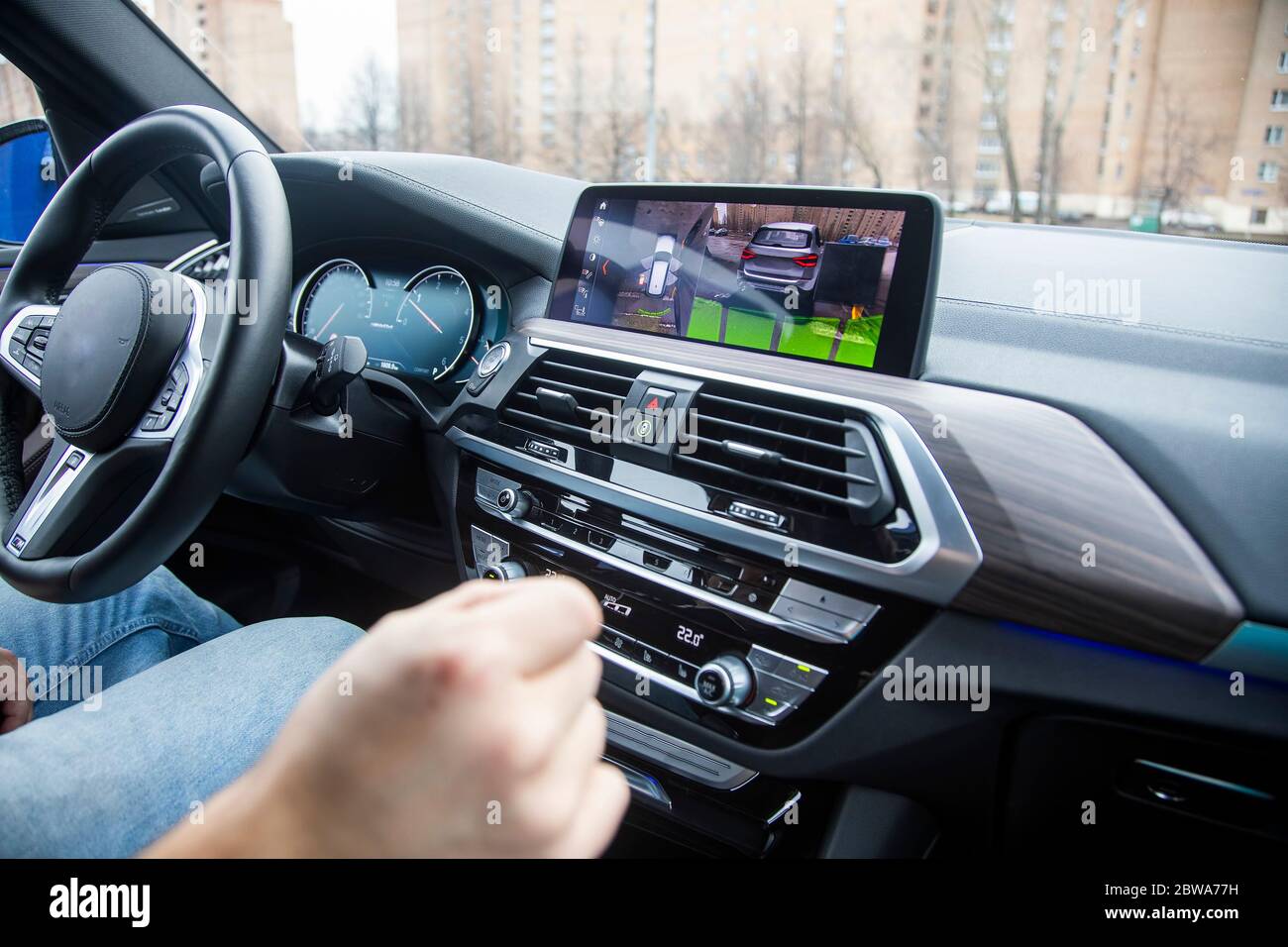 Modernes Technologiekonzept, Straßenhilfe. Man steuert eine 360 Surround View Assist System eines modernen Autos mit Gesten. Nahaufnahme, Hintergrund in Unschärfe Stockfoto