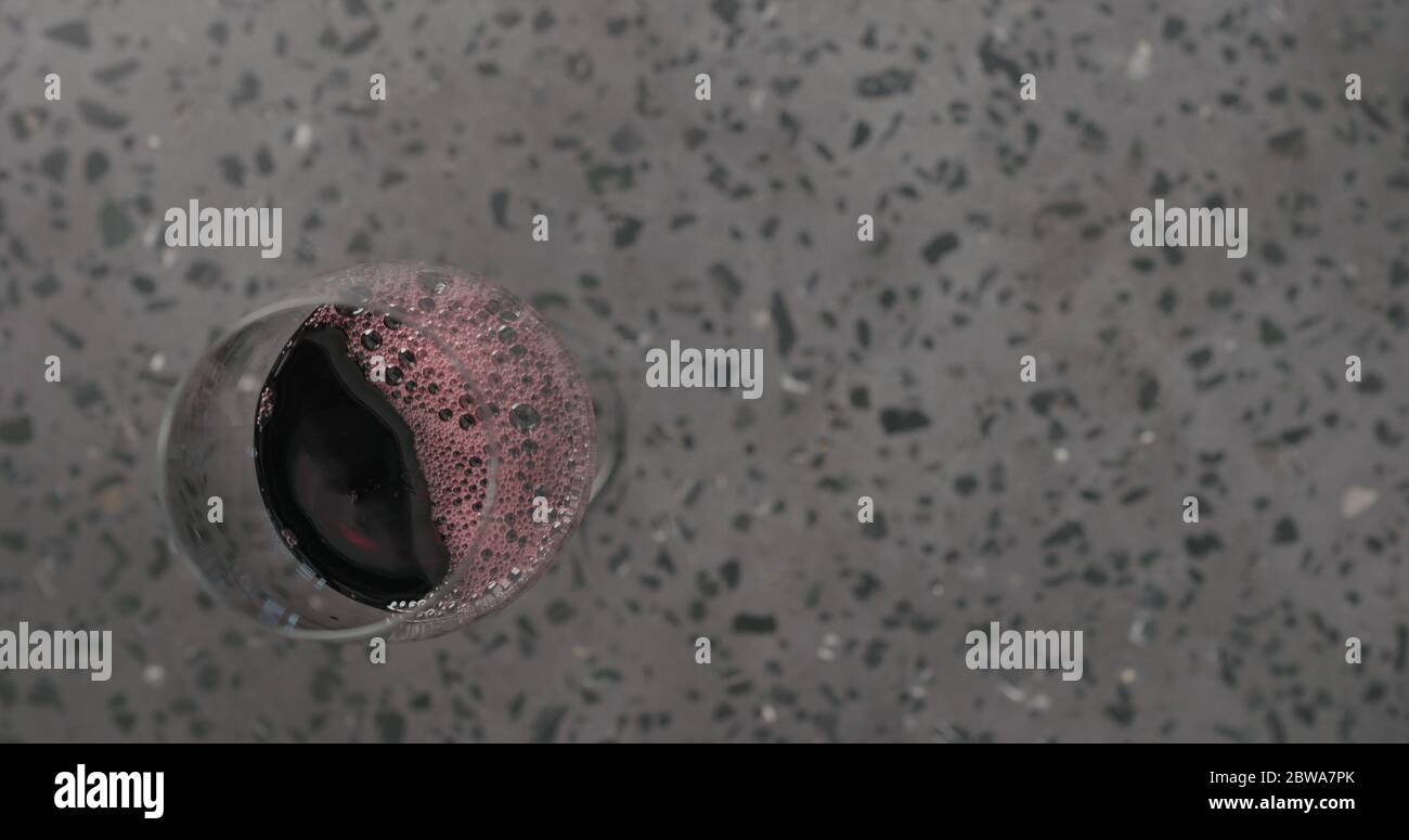 Draufsicht gießen Rotwein in Weinglas auf Beton Hintergrund Mit Kopierbereich Stockfoto