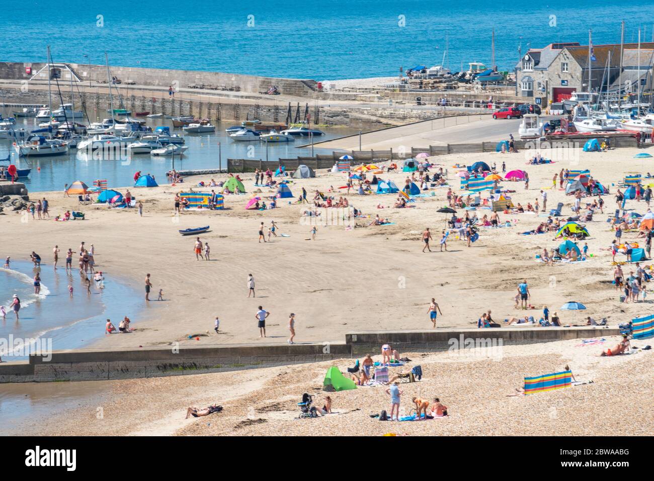 Lyme Regis, Dorset, Großbritannien. Mai 2020. Wetter in Großbritannien. Der Badeort Lyme Regis war von beschäftigt 10.30 als Familien und Strandgänger strömten früh an den Strand, um einen Platz am Strand zu sichern, um einen Tag der sozial distanzierten Sonnenbaden an einem Tag der sengenden heißen Sonne und strahlend blauen Himmel genießen. Kredit: Celia McMahon/Alamy Live News Stockfoto