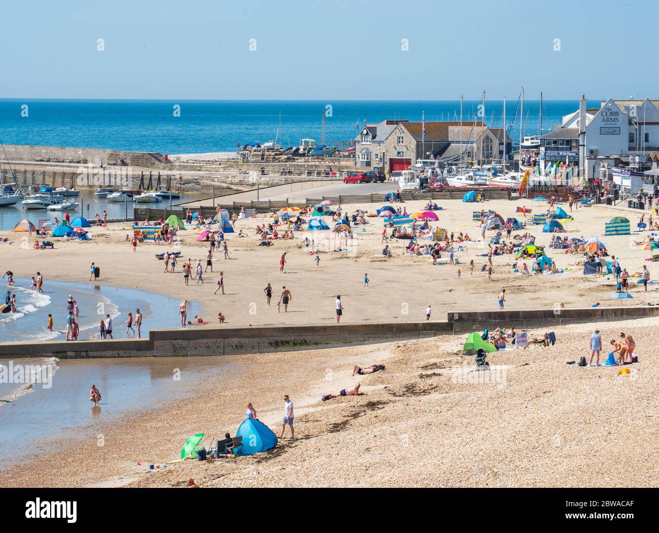 Lyme Regis, Dorset, Großbritannien. Mai 2020. Wetter in Großbritannien. Der Badeort Lyme Regis war von beschäftigt 10.30 als Familien und Strandgänger strömten früh an den Strand, um einen Platz am Strand zu sichern, um einen Tag der sozial distanzierten Sonnenbaden an einem Tag der sengenden heißen Sonne und strahlend blauen Himmel genießen. Kredit: Celia McMahon/Alamy Live News Stockfoto