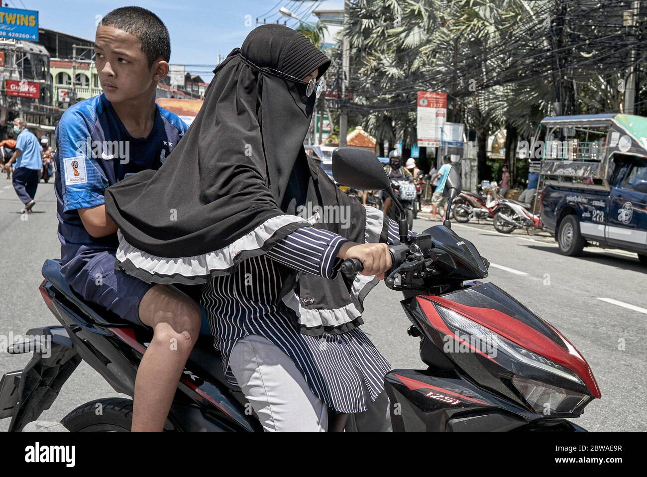 Muslimische Frau trägt traditionellen Hijab Schleier und Reiten ein Motorrad mit Sozius Beifahrer. Thailand Südostasien Stockfoto