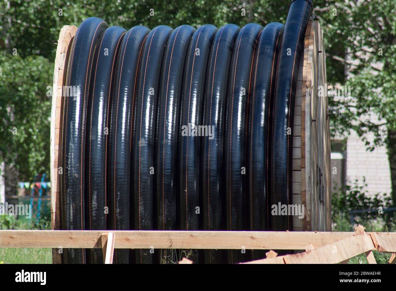 Große Polyethylenrohre in der Spule für Gas und Wasser sind am Boden liyng. Reparaturarbeiten. Stockfoto