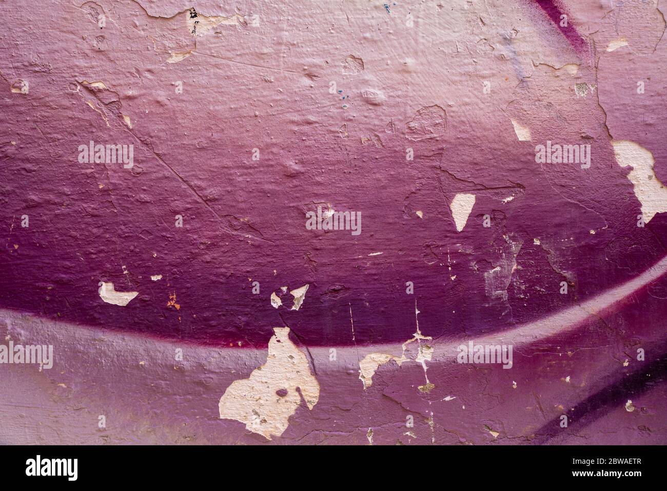 Violette und weiße bunte Wand mit abgebrochenem Lack. Nahaufnahme einer Graffiti-Textur. Street Art Hintergrund. Stockfoto
