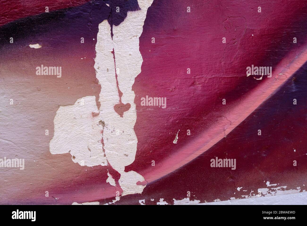 Lila und weiß bunte Wand mit abgebroschter Farbe. Nahaufnahme einer Graffiti-Textur. Street Art Hintergrund. Stockfoto