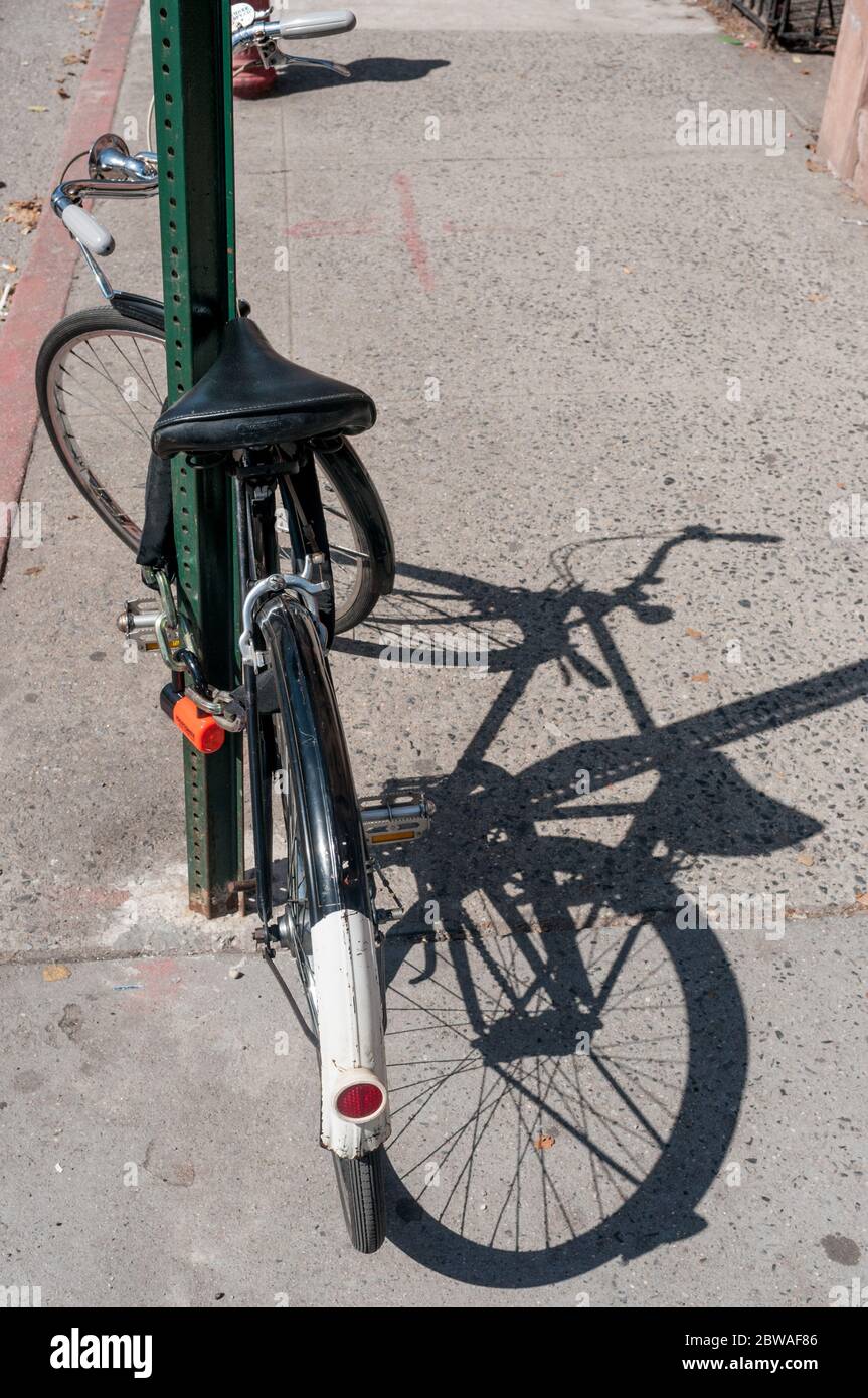 Fahrrad gesperrt zu Stange auf Bürgersteig, Brooklyn, New York, USA Stockfoto