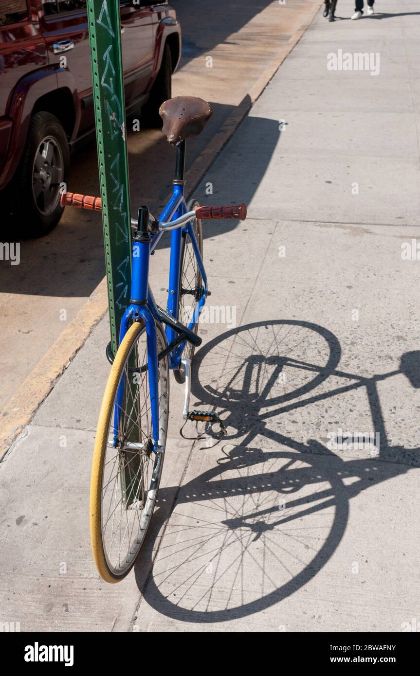 Fahrrad gesperrt zu Stange auf Bürgersteig, Brooklyn, New York, USA Stockfoto
