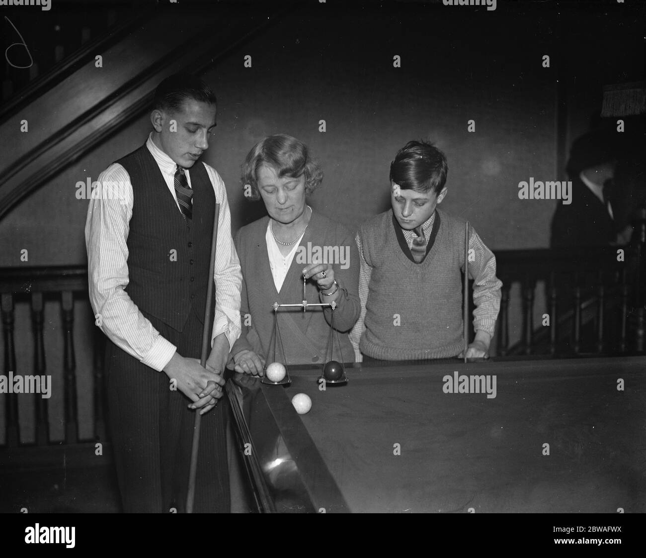 Boys Billiards Championship in der Burwat Hall, Soho Square Miss Eva Collins, der Schiedsrichter, wiegt die Bälle vor dem Spiel zwischen Jack Briggs (von Leeds) links, und J T Wright (Leicester) 28. Dezember1933 Stockfoto