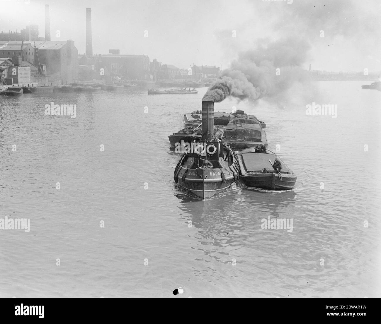 Der Schlepper Maud hat deutlich genug Kohle, um weiterzumachen und passiert im Stil des 21. März 1921 die Hammersmith Bridge Stockfoto