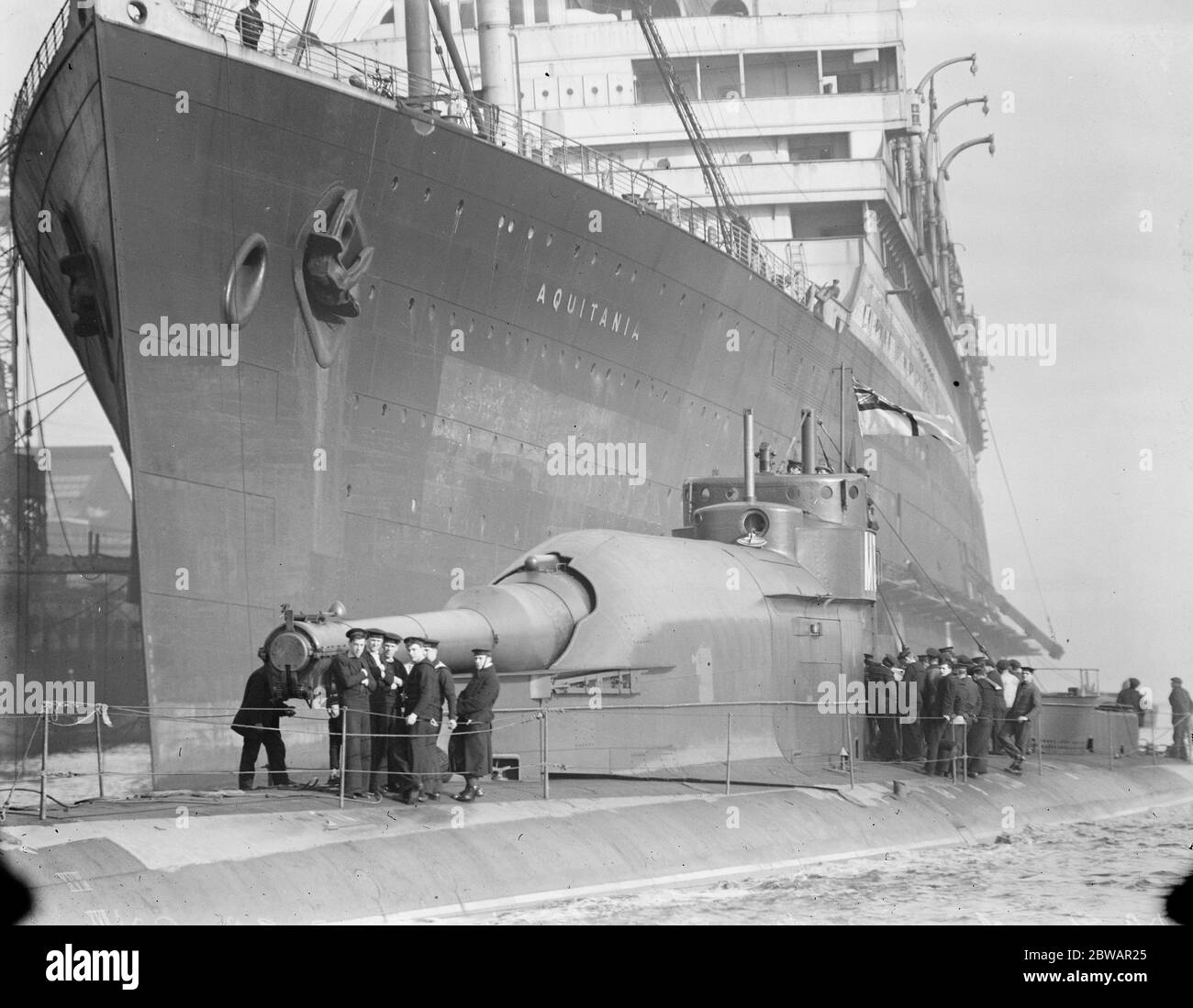 HMS Submarine No 3 das neue Tauchschiff, das neben dem Riesen Cunarder 'Aquitamia' liegt 30. März 1920 Stockfoto