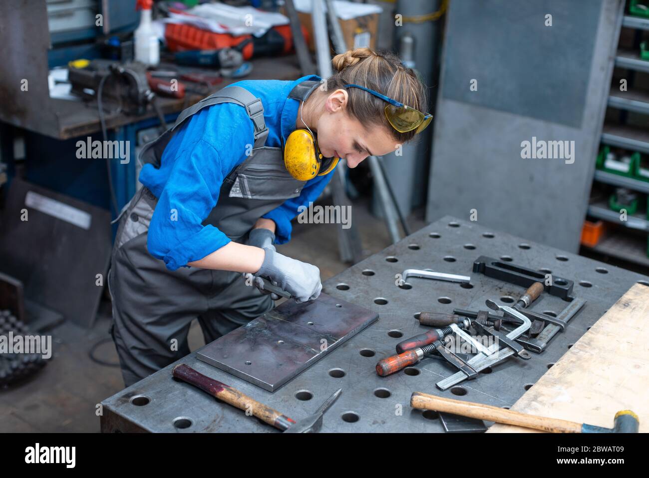 Seitenansicht des Arbeitnehmers Frau Kennzeichnung Stück Metall Stockfoto