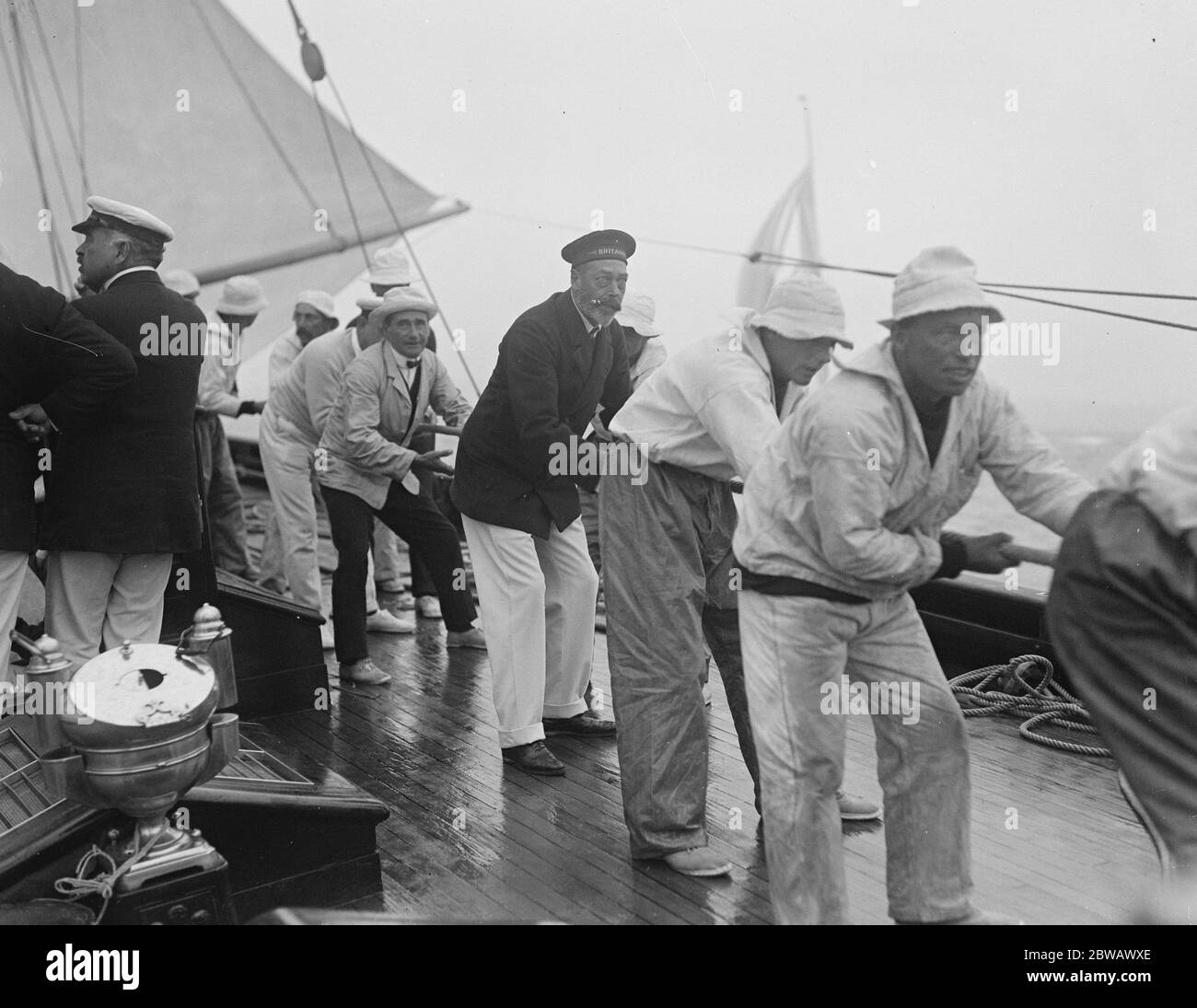 Die Kings Yacht "Britannia in Race bei Cowes auf Isle of Wight, der Südküste von England der König hilft, das Großsegel zu schleppen 2 August 1921 Stockfoto