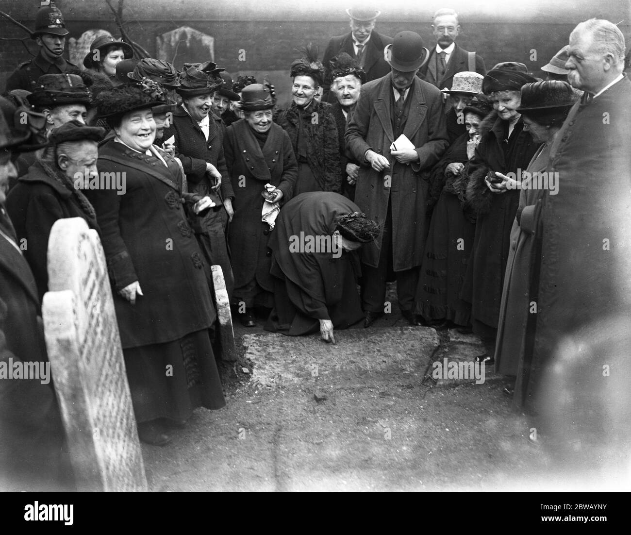 Die Verteilung der Butterworth Charity in St Bartholomew ' s Kirche , Smithfield , London . Die Verteilung von sechs und Brötchen an arme Witwen der Pfarrei . Sixpences werden auf die Grabsteine gelegt, die gesammelt werden sollen. 15. April 1922 Stockfoto