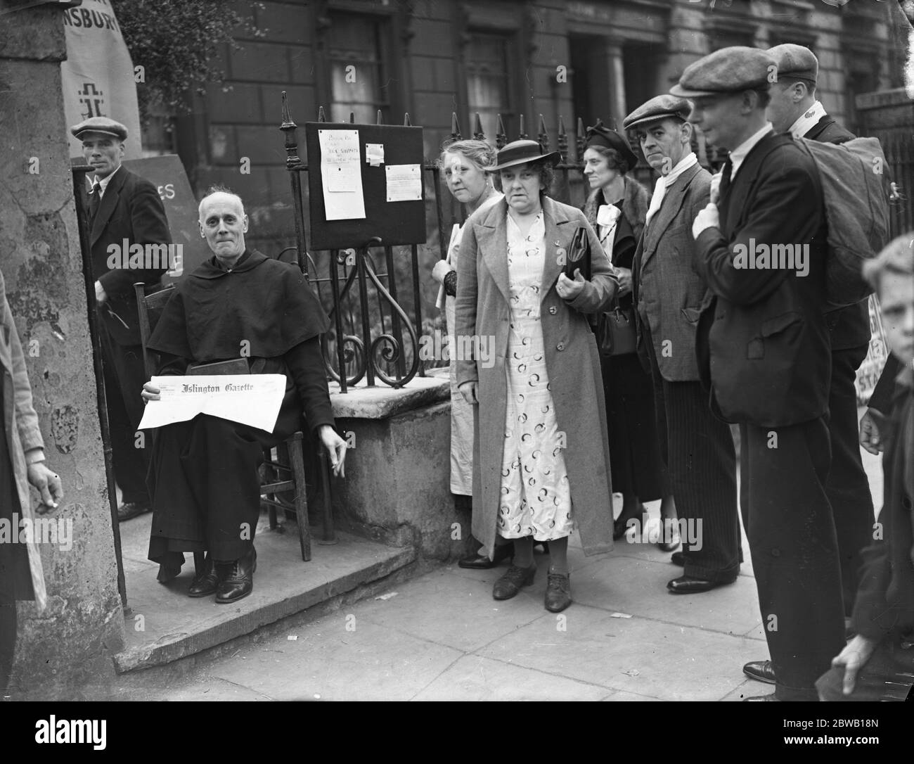 Der Reverend E O Iredell in der Veranda der St. Clement ' s Kirche, Barnsbury, Islington, um Spenden an die Kirche Fonds zu sammeln. 19 Juli 1938 Stockfoto