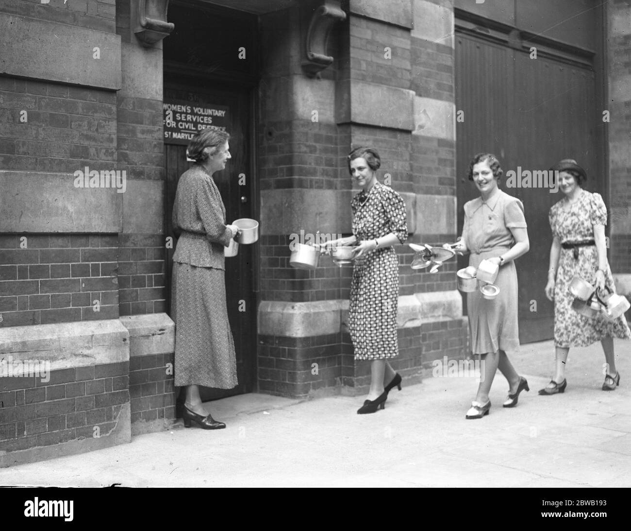 Die Öffentlichkeit machte das Sammeln von Aluminium für die Umwandlung in "Flugzeuge ein großer Erfolg. Frau Hartnell (Bürgermeister von Chelsea) wirft einen Beitrag in der Stadtsammlung in Chelsea Town Hall. Juli 1940 Stockfoto