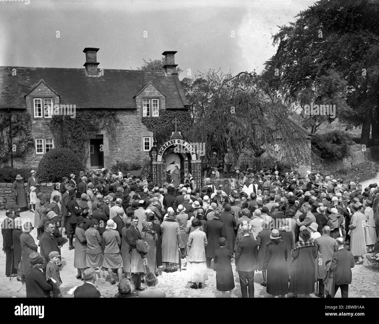 Die Szene in Tissington, Derbyshire, während der jährlichen Segen und Dekoration der Brunnen, ein Himmelfahrt-Tag-Brauch. Jeder der fünf Brunnen ist mit Hilfe von Blütenblättern und Reis in einem Hintergrund aus Ton, und ist eine Kunst, die nur den Dorfbewohnern bekannt. 29 Mai 1930 Stockfoto
